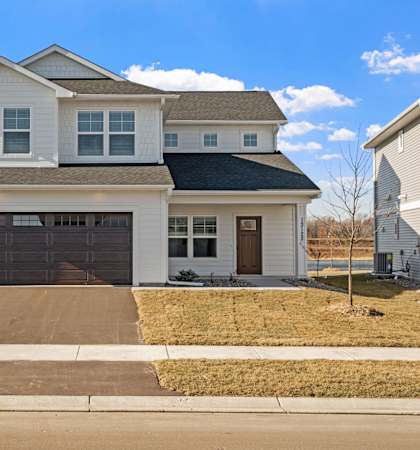 a white house with two garage doors and a driveway