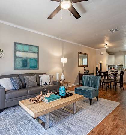 A living room with a grey couch, a wooden coffee table, and a ceiling fan.at Palazzo Townhomes, Phoenix, AZ