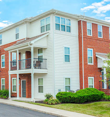 a row of brick and white apartment buildings on the corner of a street