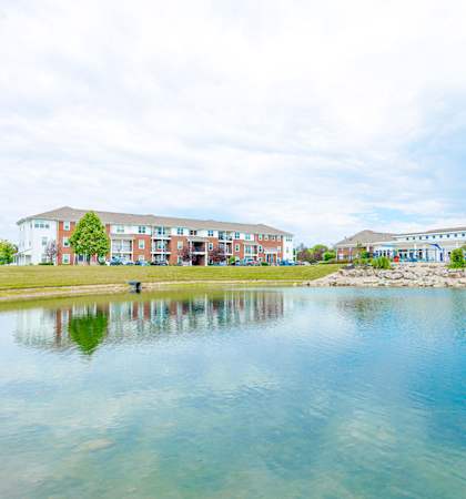 a pond with a fountain in front of a building