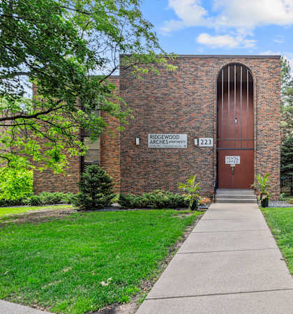A brick building with a sign that says "Bigwood Architects 223" on it.