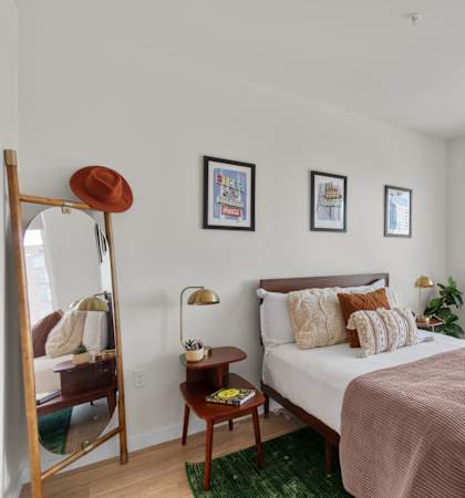 a bedroom with a large window and a large bed with a brown headboard