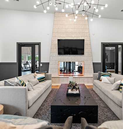 A living room with a grey couch and a black coffee table.