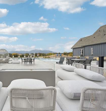 a patio with couches and chairs around a pool at The Garrison Luxury Apartment Homes, Colorado, 80817