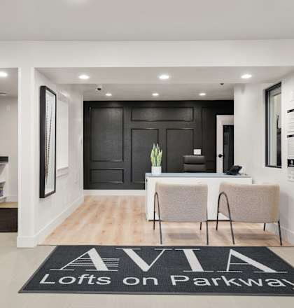 A black and white foyer with a rug that says "Lofts on Parkway".