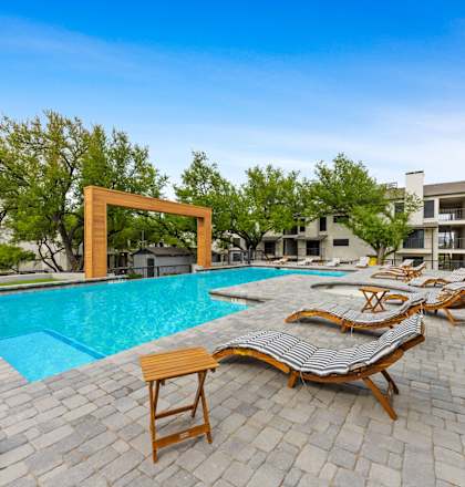 a swimming pool with chaise lounge chairs