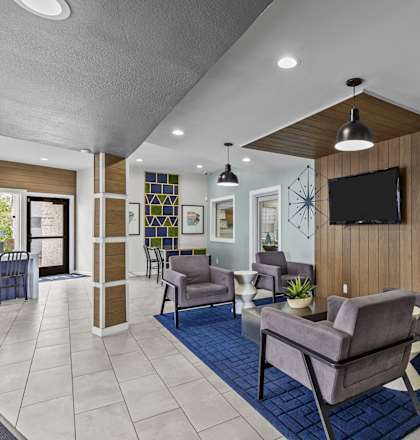 a lobby with couches and chairs and a television