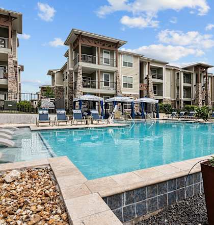 a swimming pool with an apartment building in the background