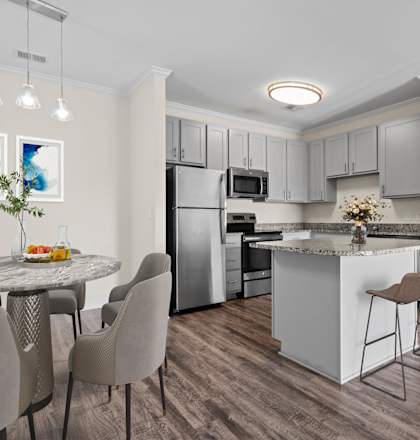 A modern kitchen with a dining table and chairs.
