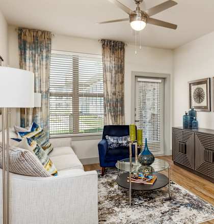 a living room with a ceiling fan and a large window