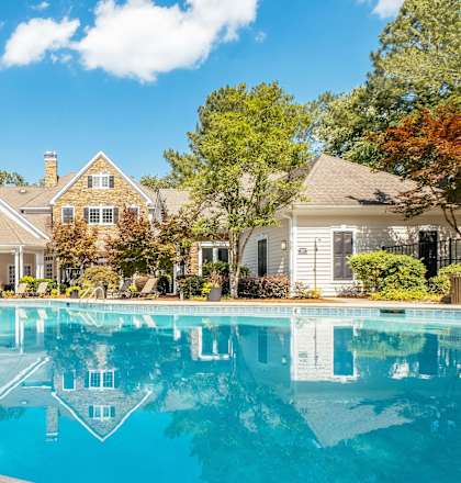 A large house with a pool in front of it.