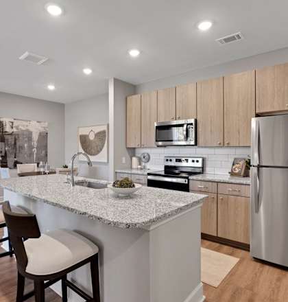 a kitchen with a marble counter top and a stainless steel refrigerator