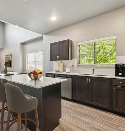 A modern kitchen with a large island and bar stools.