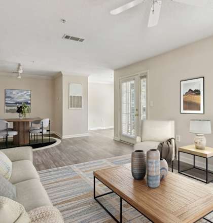 A living room with a couch, a coffee table, and a potted plant.
