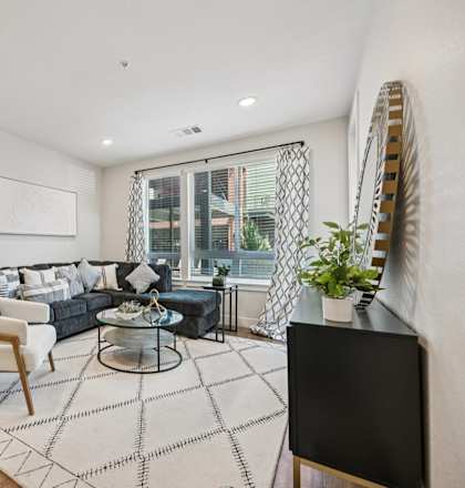 A living room with a black couch and a white chair.