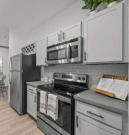 A modern kitchen with stainless steel appliances and white cabinets.