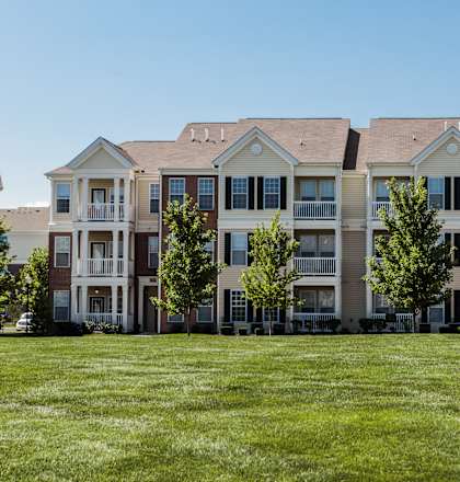 an image of an apartment building on a green lawn at Brickshire Apartments, Merrillville