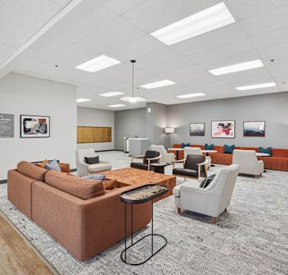 A spacious waiting room with a variety of seating options and pictures on the wall.