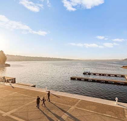 people walking on a dock overlooking a river
