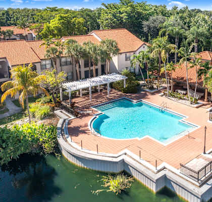 A large swimming pool surrounded by a deck and a covered patio area.