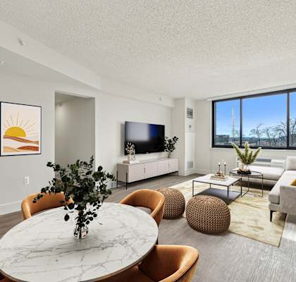 A living room with a white marble table and orange chairs.