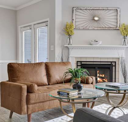 Living room with plank flooring and fireplace at Village at Caldwell Mill in Birmingham, AL
