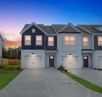A row of houses with garages and driveways.