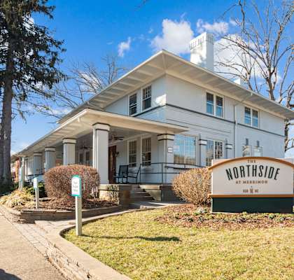 A white building with a sign that says Northside in front of it.