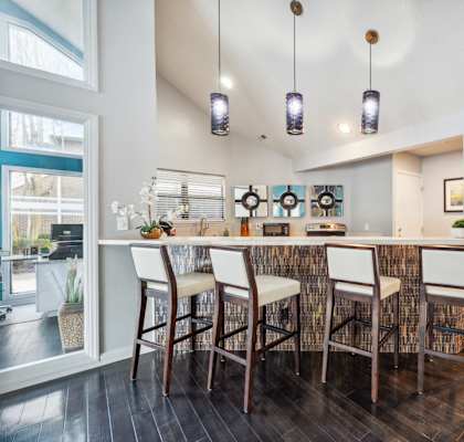 A kitchen with a bar area and chairs.