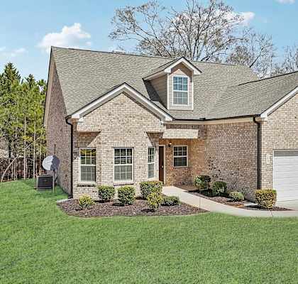 A house with a grey roof and a white garage door.