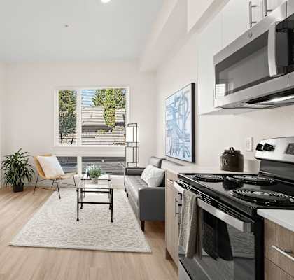 a living room with a kitchen and a large window at The Duo, University Place Washington