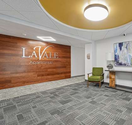 A conference room with a wooden wall and a carpeted floor.