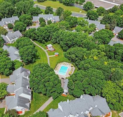 A bird's eye view of a residential area with houses and a swimming pool.
