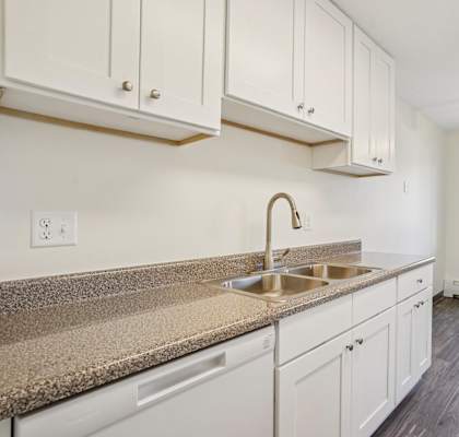 A kitchen with white cabinets and a granite countertop.