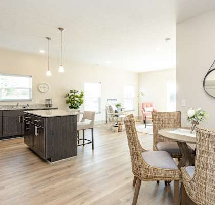 A modern kitchen with a dining table set for two.