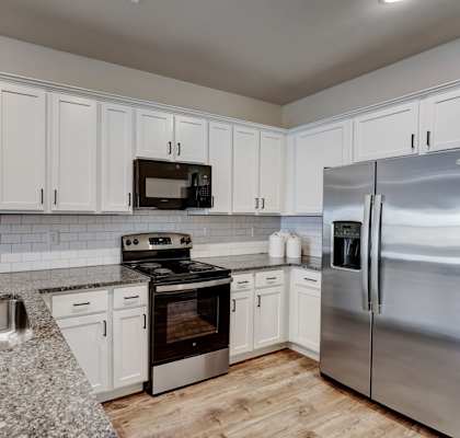 a kitchen with granite counter tops and stainless steel appliances