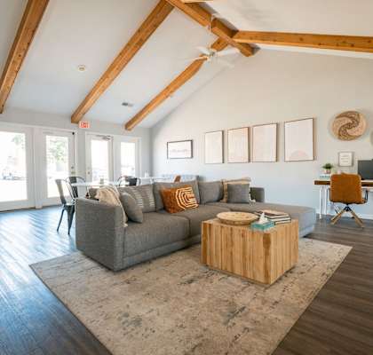 A living room with a grey couch and a wooden coffee table.