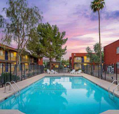 A swimming pool surrounded by a fence and buildings.