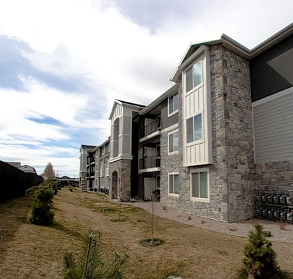 A modern two-story residential building with a stone facade.