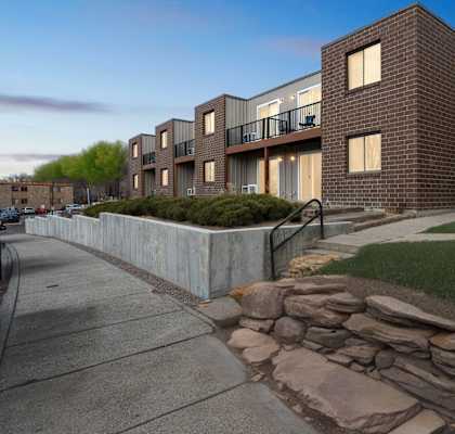 A modern brick building with a stone wall in front.