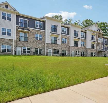 A large apartment complex with a grassy area in front.