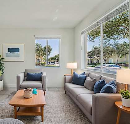 A living room with a grey couch, a wooden coffee table, and a flat screen TV.