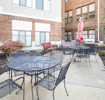 A patio with a table and chairs is surrounded by a brick building.