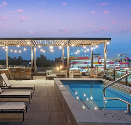 A pool area with sun loungers and a roofed seating area.