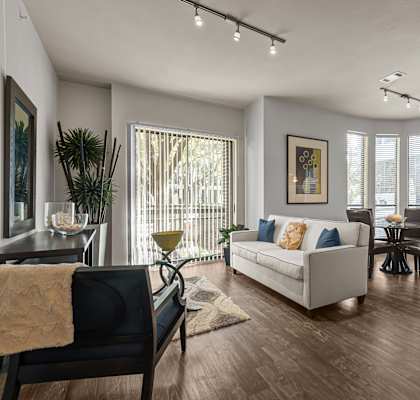 A modern living room with a white couch and a wooden floor.