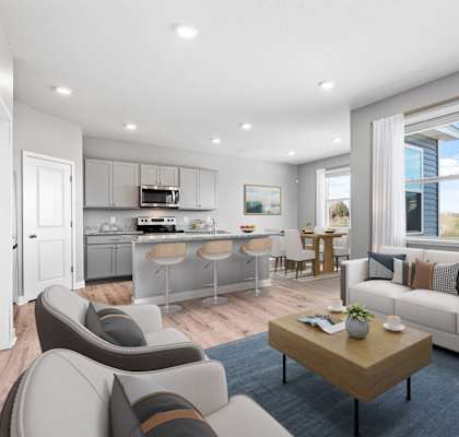 A modern living room with a kitchen area in the background.