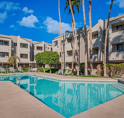 A swimming pool in front of apartment buildings.