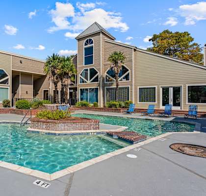 A pool area with a building in the background.
