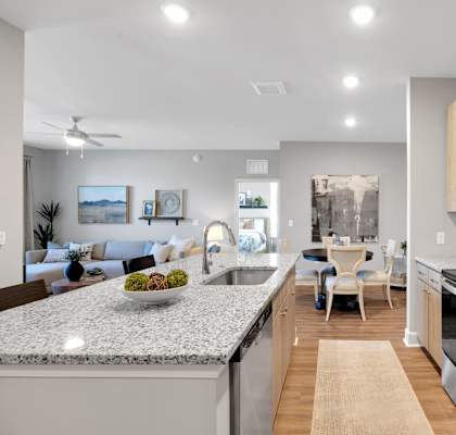 kitchen and living room with granite counter tops and stainless steel appliances