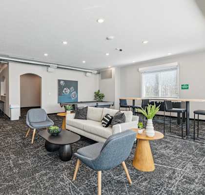 A modern living room with a grey carpet and furniture.